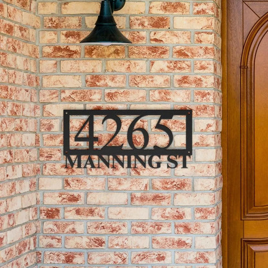 custom metal house number sign in black steel mounted on brick wall near wooden door